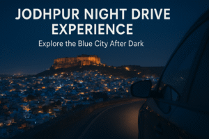 "Night drive in Jodhpur with view of illuminated Mehrangarh Fort and blue city lights under a dark sky"